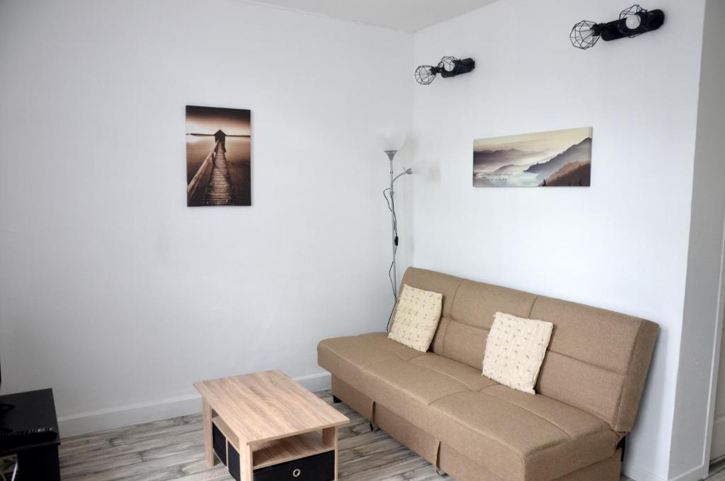 sala de estar con sofá y mesa en studio "Au Bord de l'Eau" 2, en Chambon-sur-Voueize