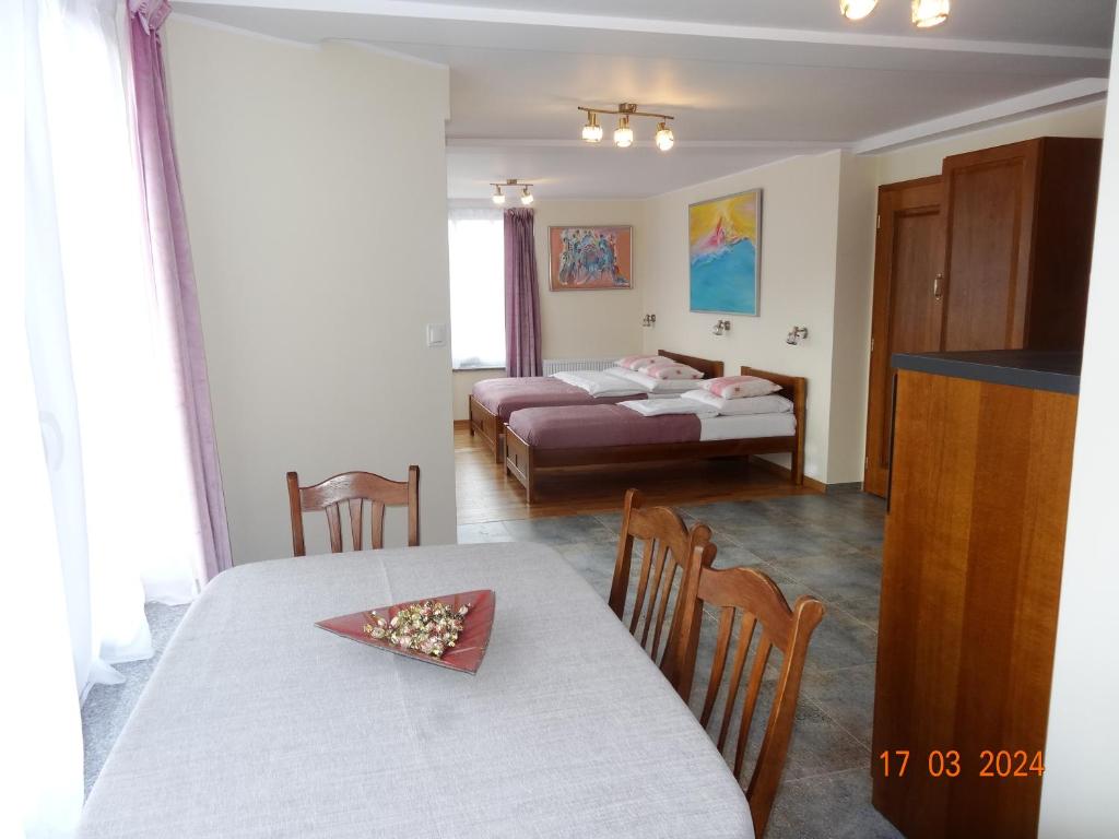 a living room with a table and a bed at APARTAMENTY i POKOJE "PASJA" - 2 minuty do plaży in Dźwirzyno