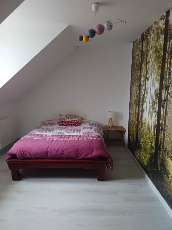 um quarto com uma cama com um edredão roxo em Location chez l habitant em Argentré-du-Plessis