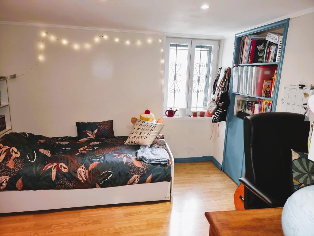 - une chambre avec un lit et une étagère avec des livres dans l'établissement NICE LOCATION EASY ACCESS TO STADIUM FOR OLYMPIC GAMES PARIS 2024, à Colombes