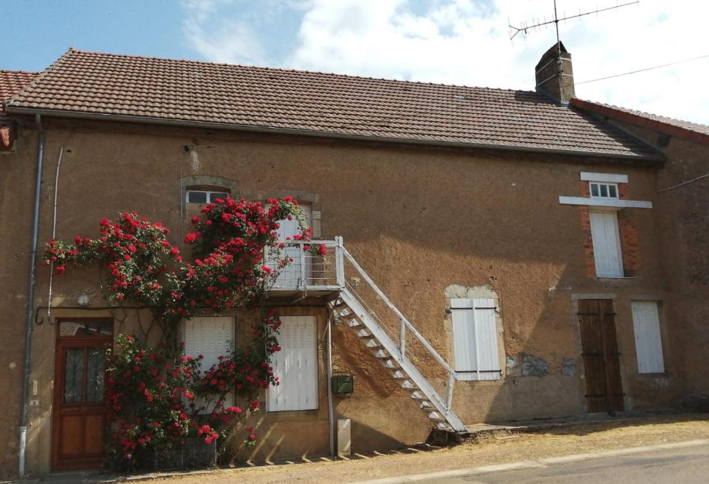 ein Haus mit Blumen auf der Seite in der Unterkunft Chez Marie et Lucien in Vianges