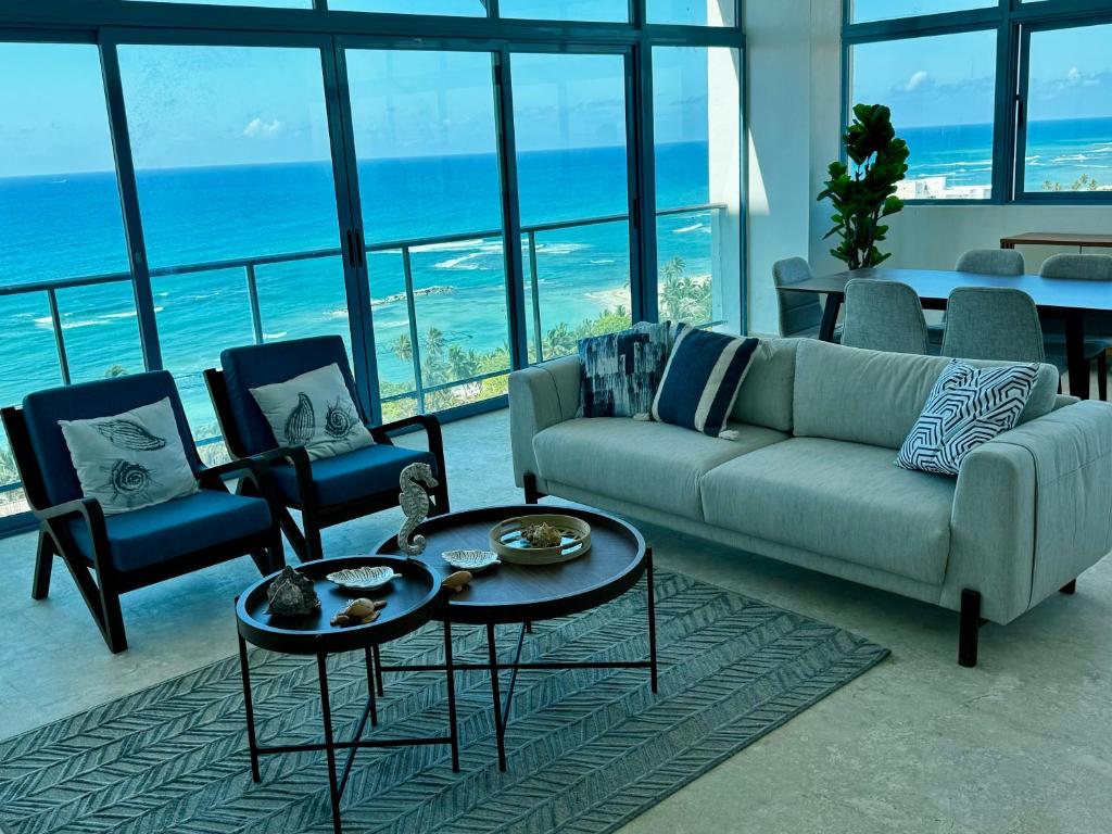 un soggiorno con divano, sedie e vista sull'oceano di Juan Dolio, Beach Access 2 BR Apt Salitre Tower front of Club Hemingway a Juan Dolio
