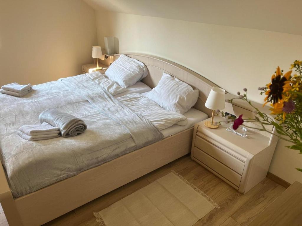 Una cama con sábanas blancas y almohadas en un dormitorio en Różany Dom w Dominikowie, en Dominikowo