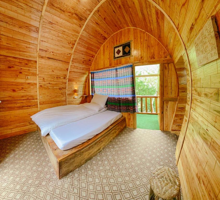 1 dormitorio con 1 cama en una habitación de madera en A Hòa Homestay, en Ye Yen Sun Cay