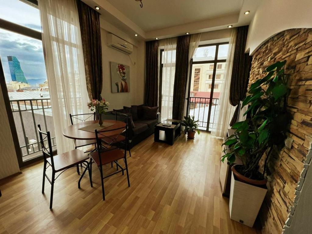 a living room with a table and chairs at Cozy apartment in the city center Mtatsminda in Tbilisi City