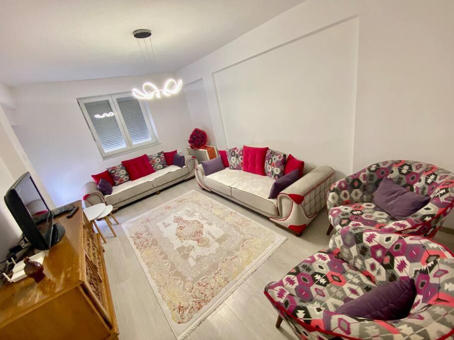 a living room with two couches and a tv at Lovely flat , full furnished with free parking in Prizren