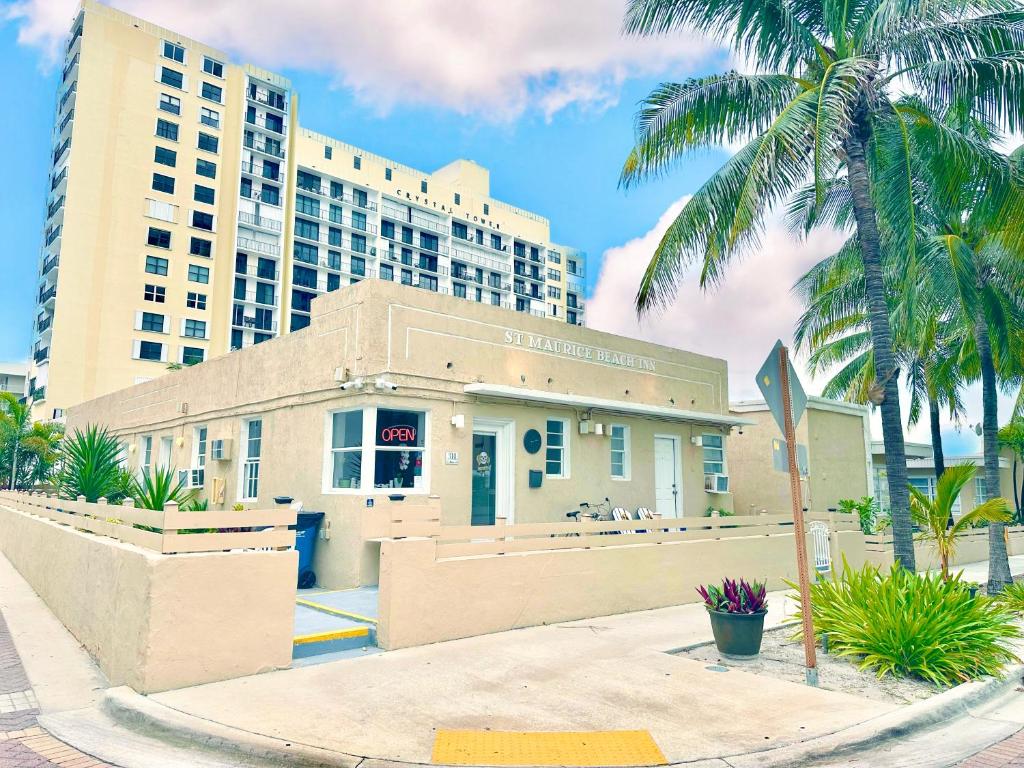 ein Gebäude vor einem hohen Gebäude mit Palmen in der Unterkunft St Maurice Beach Inn in Hollywood
