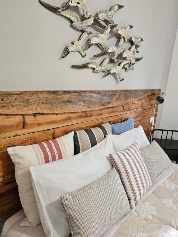 una camera da letto con testiera in legno e cuscini su un letto di VILLA VILLACOLLE a Procchio