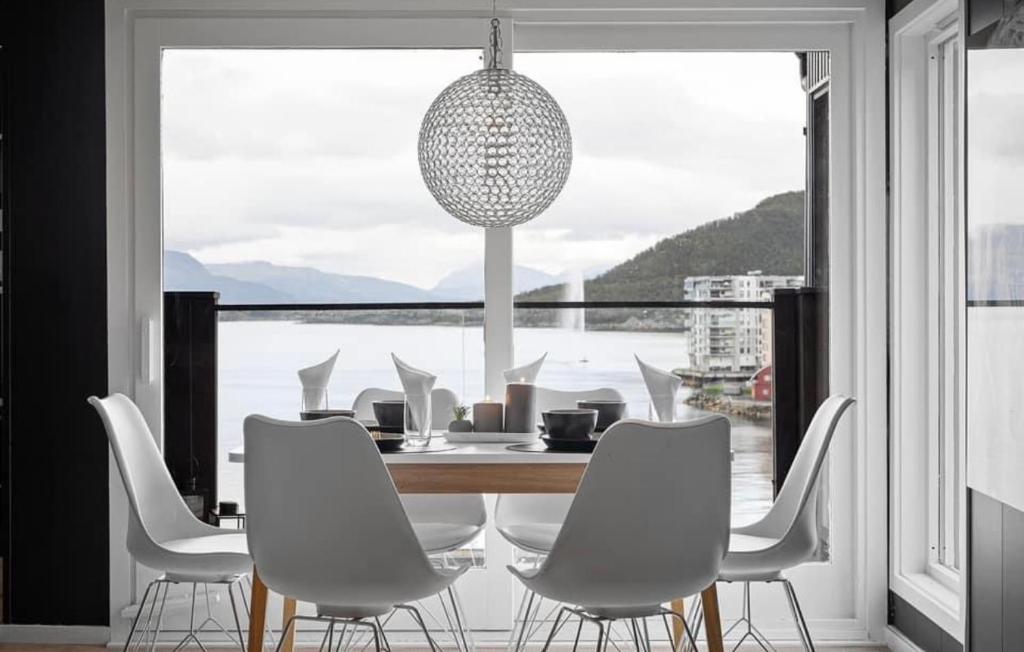 a dining room with a table and chairs and a large window at AA Home Solgryveien Harstad in Harstad