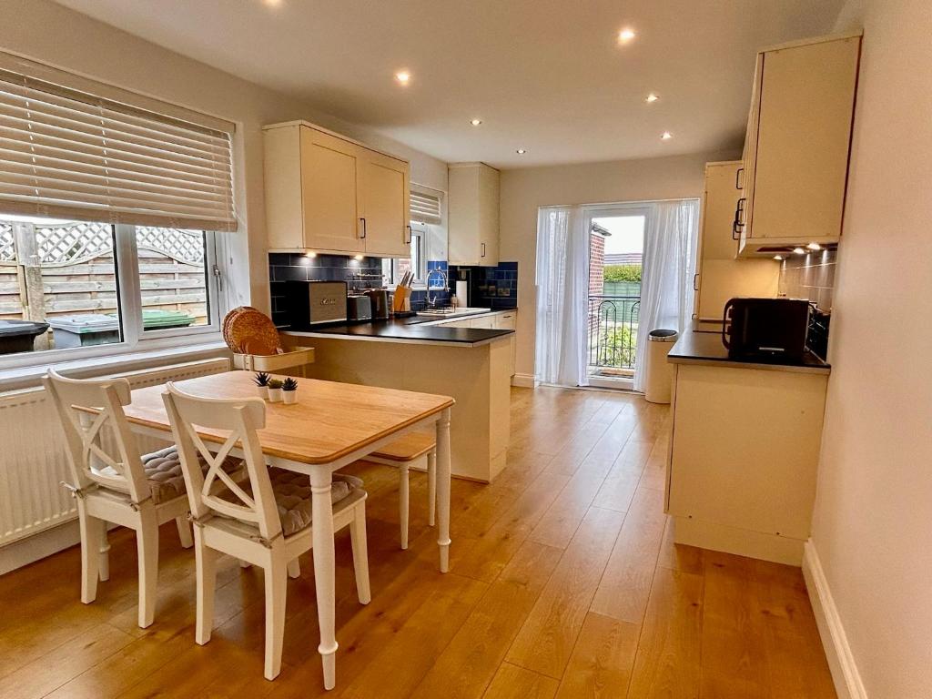 a kitchen with a wooden table and chairs in a room at Nature Inspired Bungalow with 3 rooms - 10 mins from Manchester Airport in Timperley