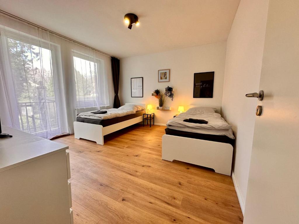 2 łóżka w pokoju z drewnianą podłogą w obiekcie Frisch sanierte 2-Zimmer-Wohnung bis zu 5 Personen w Bremie