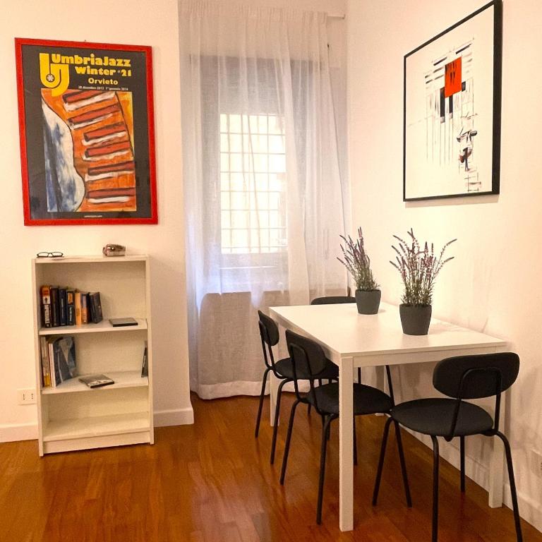 una sala da pranzo con tavolo e sedie bianchi di Lazy Time Apartment a Roma