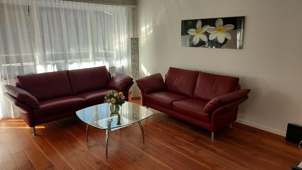 ein Wohnzimmer mit einem Sofa und einem Glastisch in der Unterkunft Apartment Heidi in Spiez