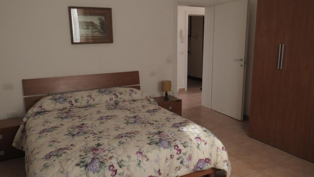 a bedroom with a bed with a floral bedspread at Casa Travaglini in Fano