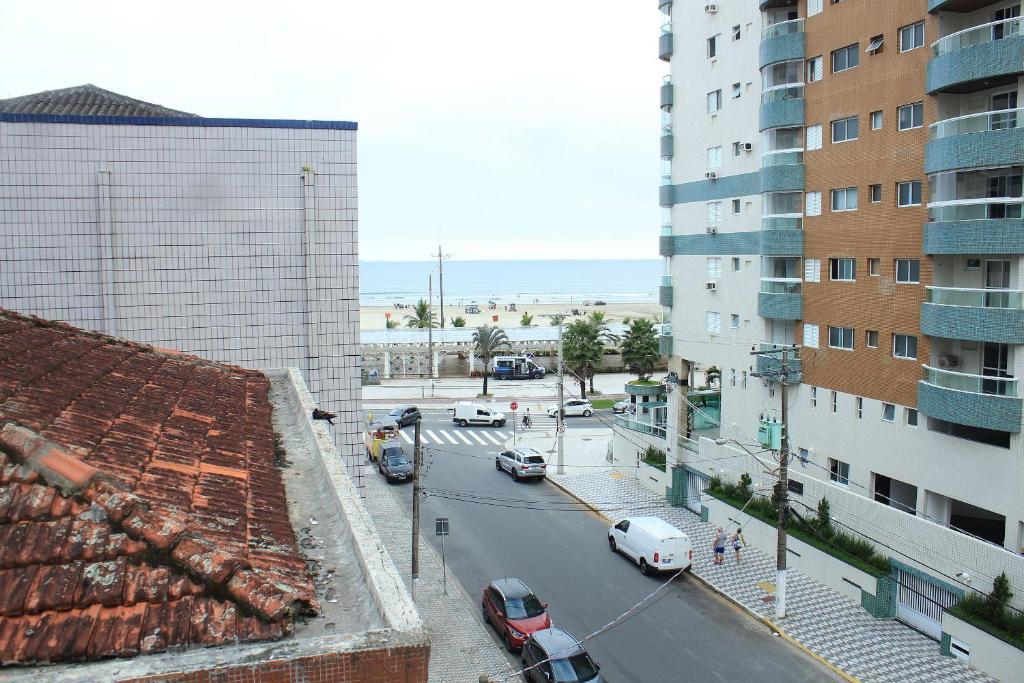 una calle de la ciudad con coches estacionados al lado de un edificio en Pé na Areia Praia da Guilhermina, en Praia Grande
