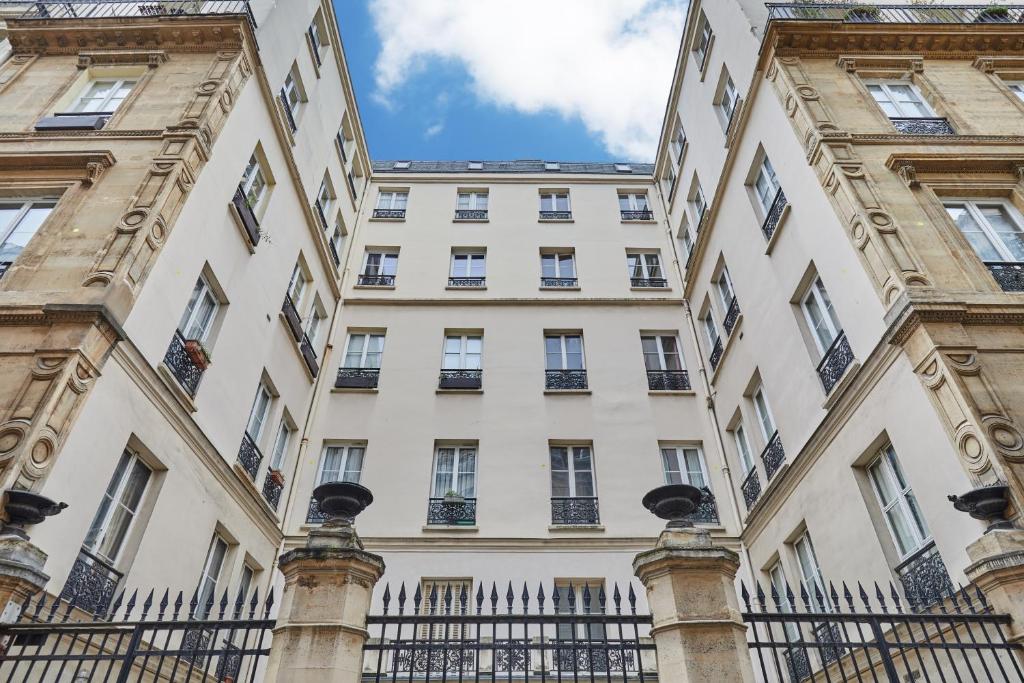 un bâtiment avec une clôture devant lui dans l'établissement Résidence Center of Paris by Studio prestige, à Paris