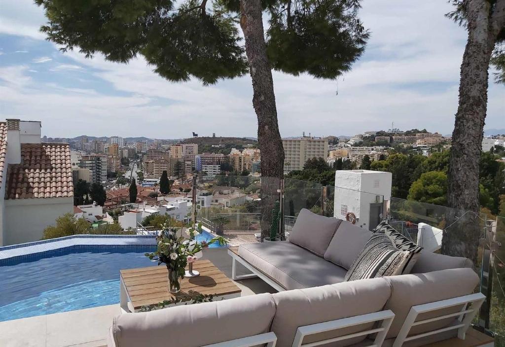 a couch on a balcony with a view of a city at Modern townhouse with stunning view in Fuengirola