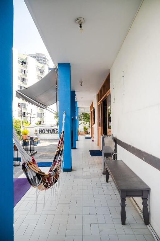 a porch with a hammock and a bench and a building at Nomads Hostel Multicultural & Coworking in Salvador