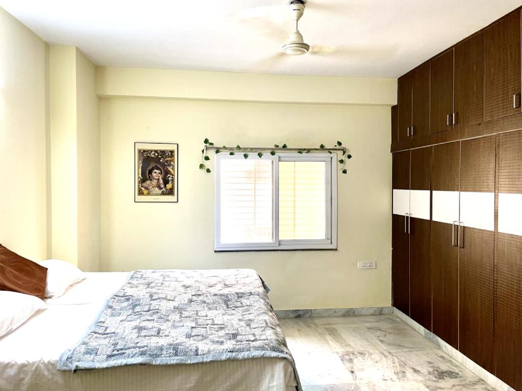 a bedroom with a bed and a window at sai bliss in Puttaparthi