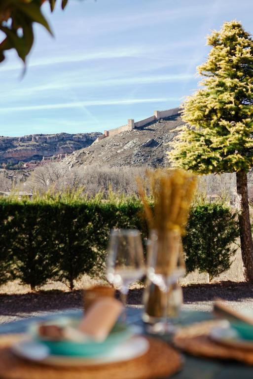 a table with plates and glasses on top of it at Casa Cauma Apartamento in Albarracín