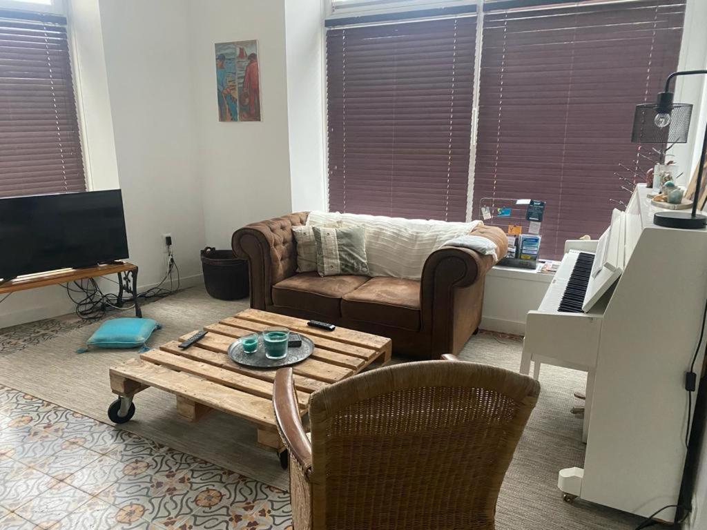 een woonkamer met een bank en een salontafel bij TY MAI - petite maison proche plages et commerces in Trébeurden