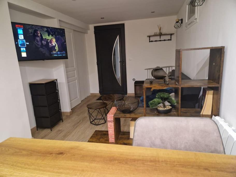 a living room with a couch and a tv on the wall at Charming apartment near La Défense, Paris in Bezons