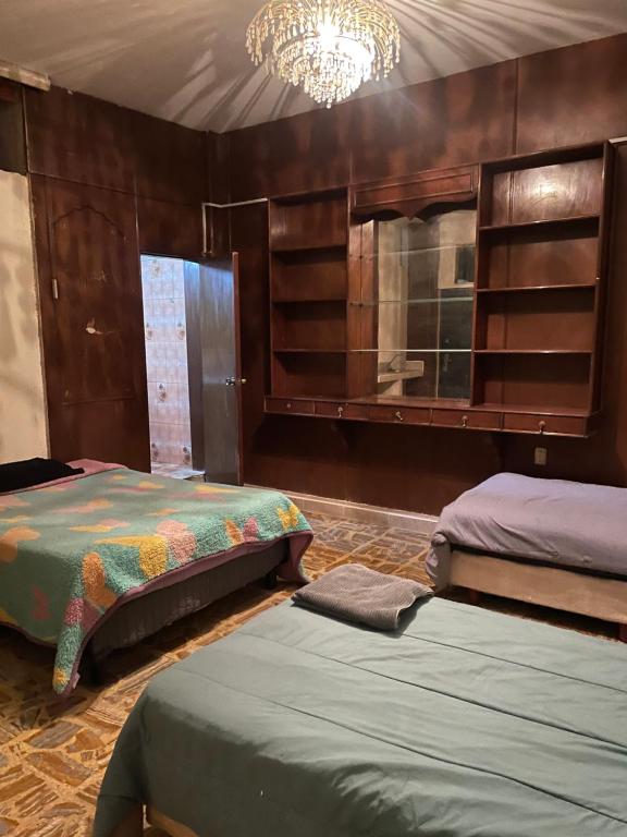 a bedroom with two beds and a chandelier at Alojamiento Registrado in Mexico City