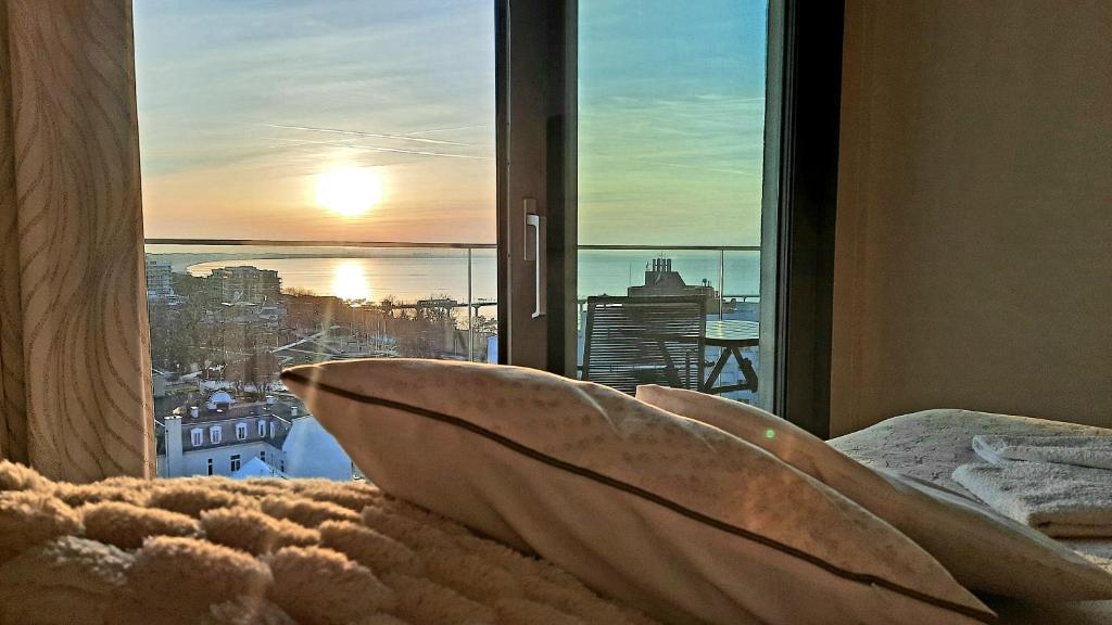 1 dormitorio con ventana y vistas al océano en Komfortable strandnahe Ferienwohnung A103 in 10 Etage mit Terrasse und Meerblick PARKING FREE, en Międzyzdroje