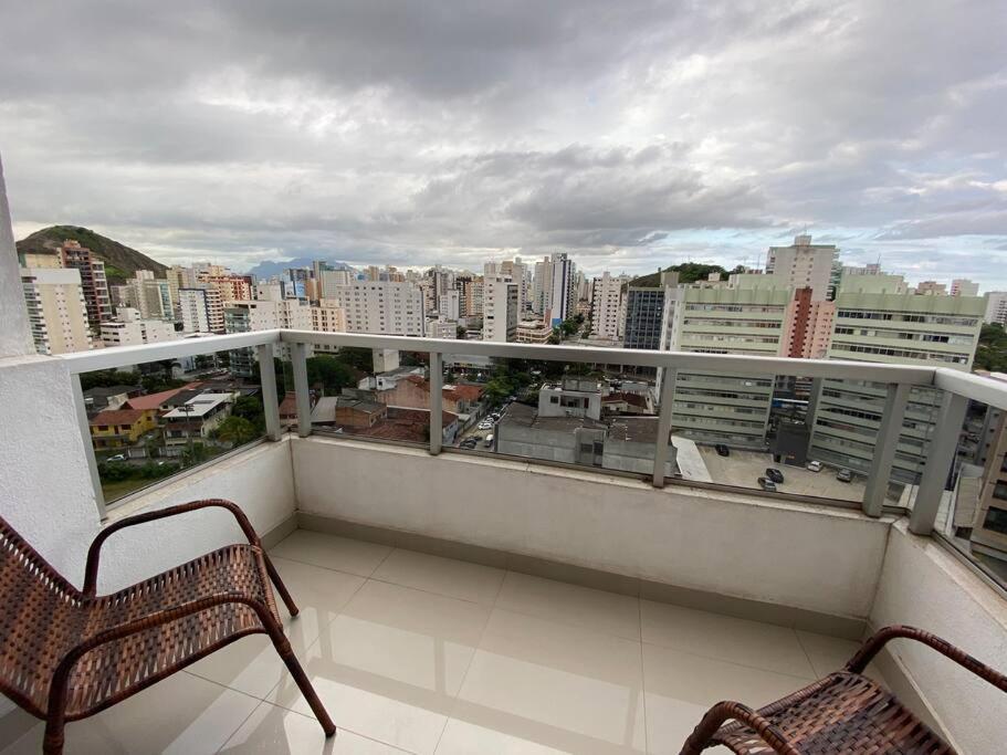 een balkon met 2 stoelen en uitzicht op de stad bij Apartamento aconchegante e bem localizado! in Vitória