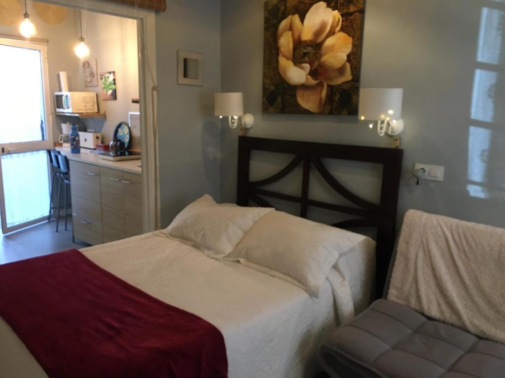 a bedroom with a bed and a chair in it at Apartamento con encanto Manchigon in Palomares del Río