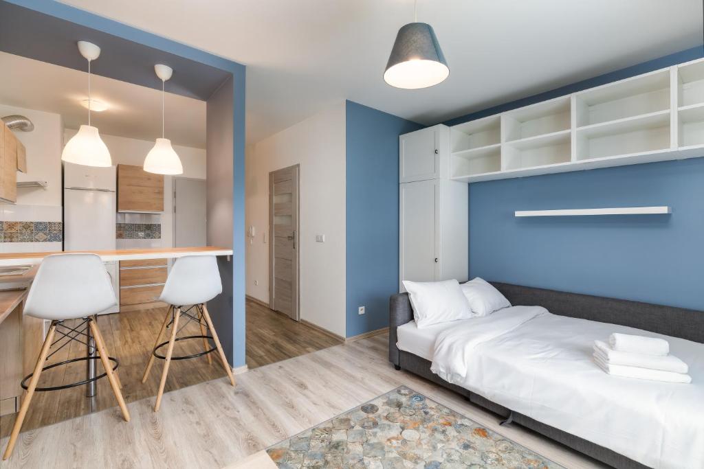 - une chambre avec un lit et un mur bleu dans l'établissement Bronowice Standard Studio, à Cracovie