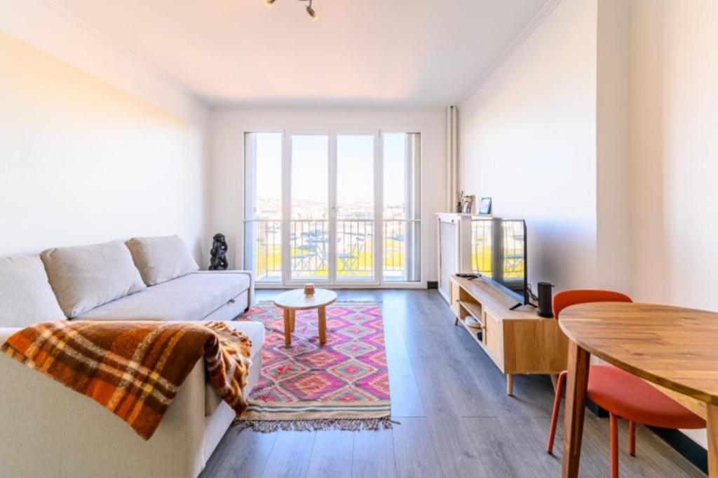 a living room with a couch and a table at Magnifique duplex Cosy Gare Terrasse 4Pers in Argenteuil
