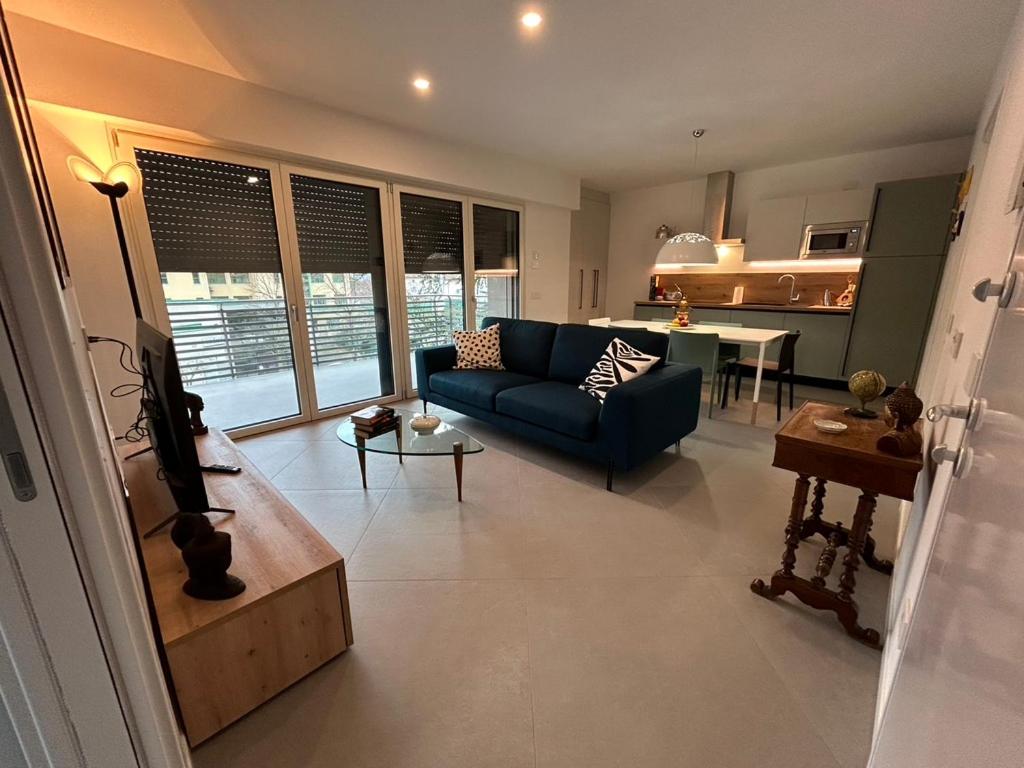 Una sala de estar con un sofá azul y una cocina. en appartamento Maria Luigia, en Riva del Garda