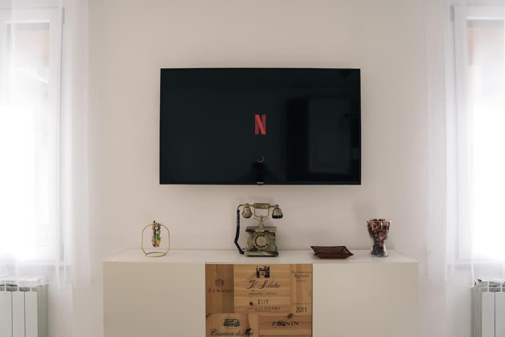 Telewizor na białej ścianie z pudełkiem pod nim w obiekcie COZY HOUSE Relax Wi-Fi & Design w mieście Colle Brianza