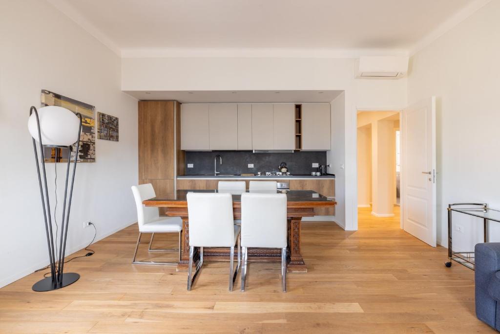 eine Küche und ein Esszimmer mit einem Tisch und weißen Stühlen in der Unterkunft Top Floor Apt with Rooftop Terrace near St. Peter in Rom