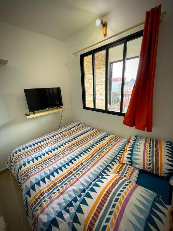 a bedroom with a bed and a flat screen tv at Studio des vagues in Lacanau