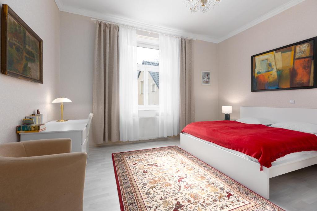 - une chambre blanche avec un lit rouge et une fenêtre dans l'établissement Apartment ZAMECKY VRCH GETAWAY, à Karlovy Vary