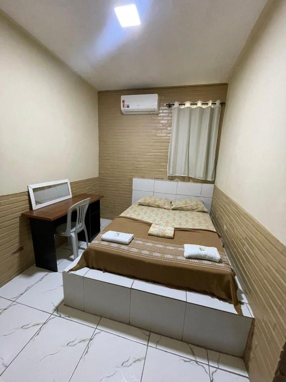 a bedroom with a bed and a desk with a computer at Hotel Paradiso in João Pessoa