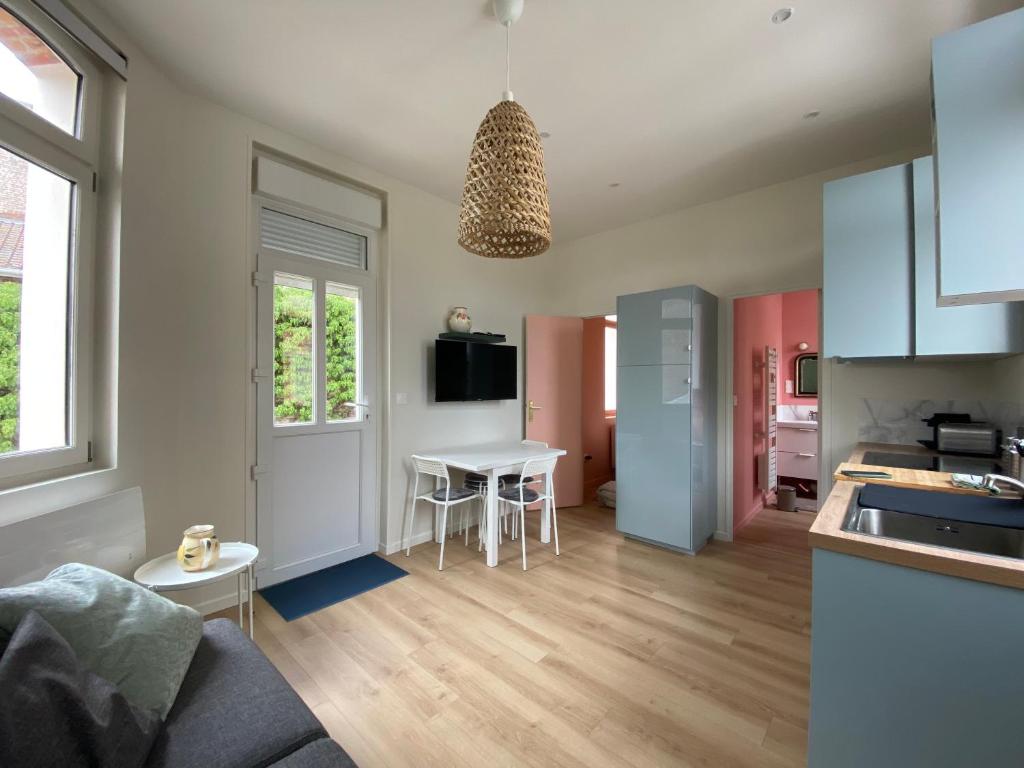 cocina y sala de estar con mesa y sillas en Superbe appartement avec chambre, proche plage, en Le Touquet-Paris-Plage