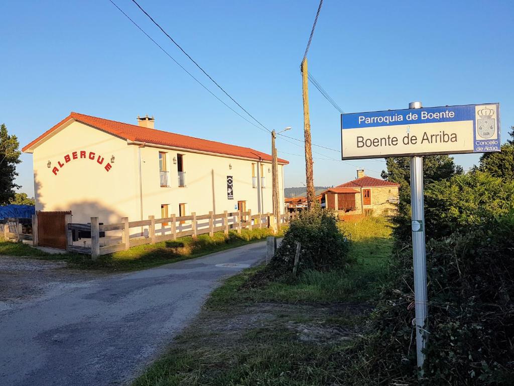 un cartello stradale di fronte a un edificio di Albergue El Aleman a Boente