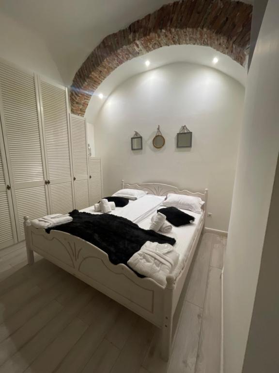 una camera con letto bianco e soffitto a volta di Luxury Ultra Central a Sibiu