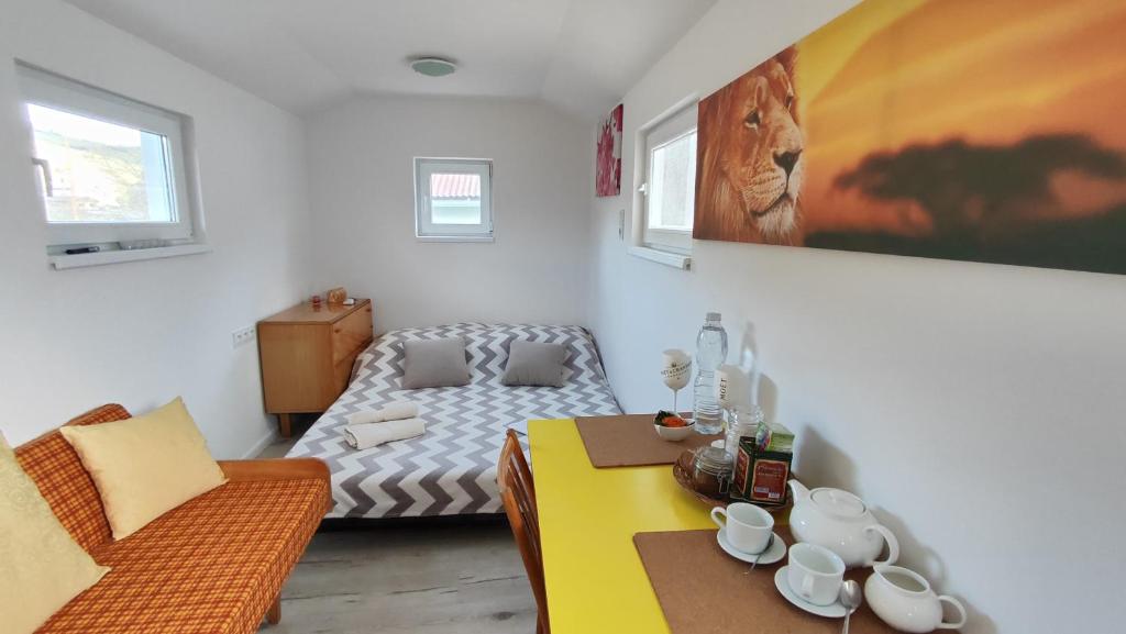 a living room with a yellow table and a bed at Apartmán tiny house v prírode 