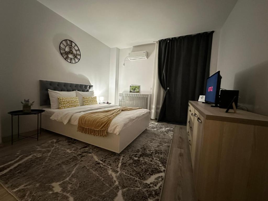 - une chambre avec un lit et une horloge murale dans l'établissement Panoramic Sunrise near IULIUS MALL by cityZen Suites, à Iaşi