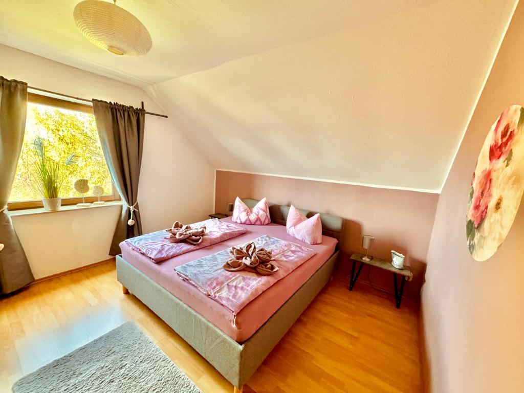 Schlafzimmer mit einem Bett mit rosa Bettwäsche und einem Fenster in der Unterkunft Ferienwohnung PIER 7 in Große Mühle