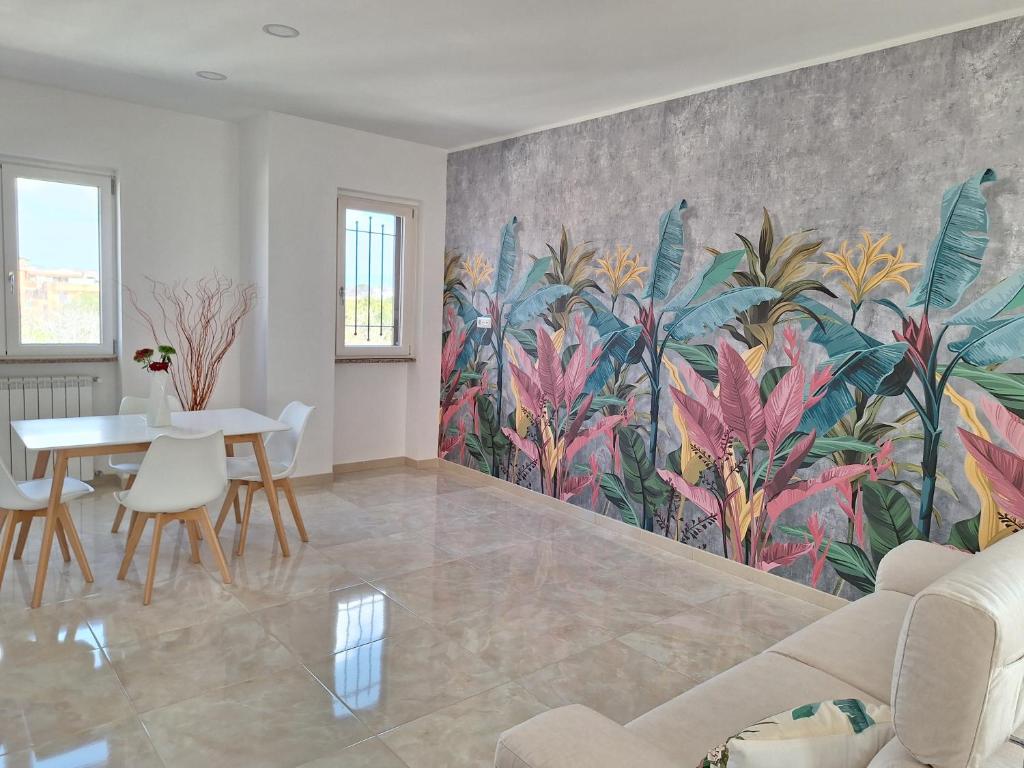 una sala de estar con una pared con un mural de plantas en Mimì Luxury Apartment, en Pompeya