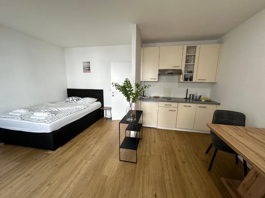 1 dormitorio con cama, mesa y cocina en City Apartments Wien, en Viena