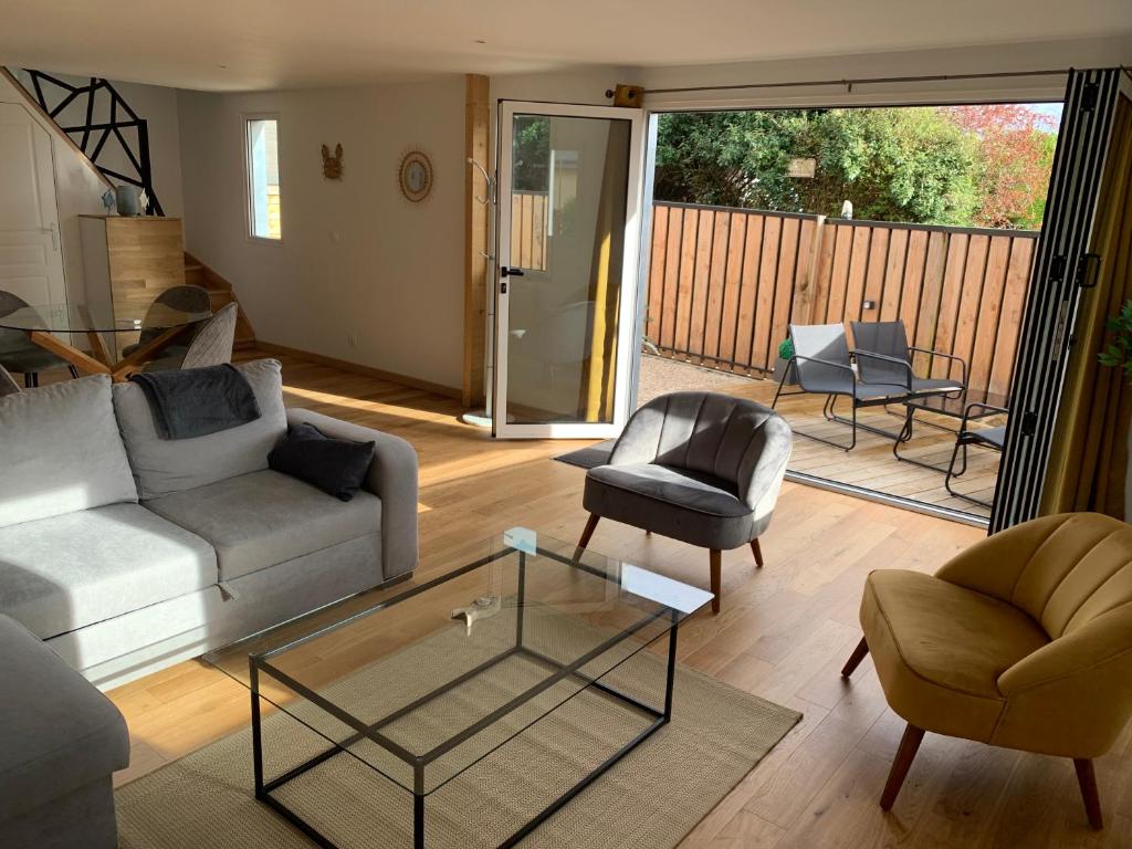 sala de estar con sofá, sillas y mesa de cristal en ENHOTI, en Plouër-sur-Rance