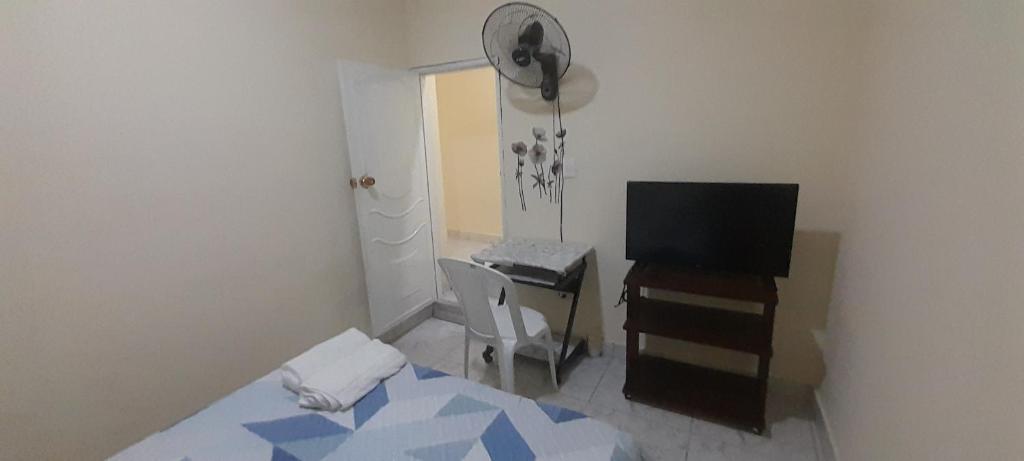 a bedroom with a bed and a desk and a television at Serenidad en Combia - Tu hogar fuera de tu hogar in Pereira