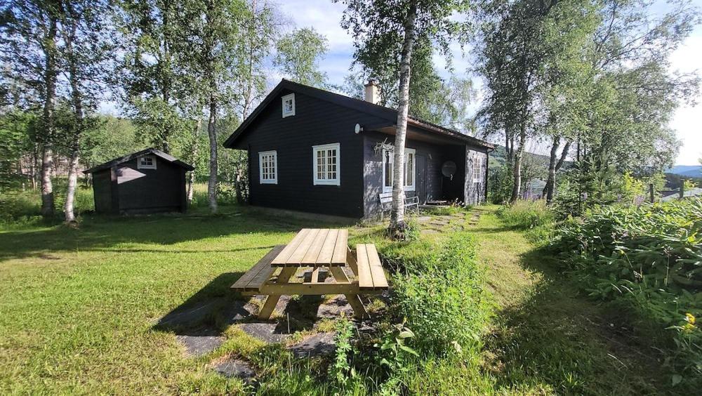 a picnic table in front of a black house at Øen cabin in Geilo by Norgesbooking in Geilo