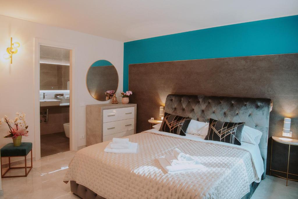 a bedroom with a large bed with a blue wall at La Luce di Sirmione in Sirmione